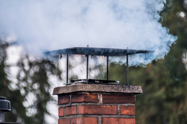 Smoking chimney and pipe on the top of a house in rural area